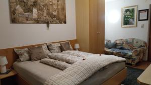 a bedroom with a bed and a chair at Thalerhof in Roppen