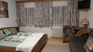 a bedroom with a bed and a couch at Thalerhof in Roppen