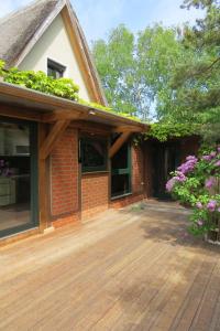 a porch of a house with a wooden deck at Strandhaus Möve in Wustrow