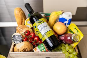 a crate of fruit and vegetables with a bottle of wine at Paplanka Boutique Cabin in Nyírbátor