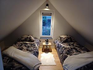 a attic room with two beds and a window at De Eekhoorn in Ugchelen