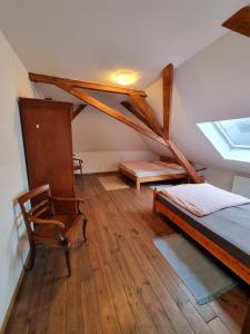 a bedroom with a bed and a chair in a attic at Ferienwohnung über den Dächern im alten Pastorat in Kevelaer
