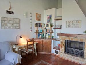 a living room with a desk and a fireplace at Casa Rural en Málaga, donde el tiempo se detiene in Las Casillas