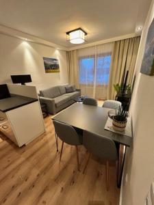 a living room with a table and a couch at Sonnhang Apartment Unterkofler in Sankt Johann im Pongau