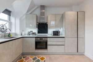 a kitchen with stainless steel cabinets and a microwave at Luxury 2-Bedroom Apartment, Leatherhead, Sleeps 4 in Leatherhead