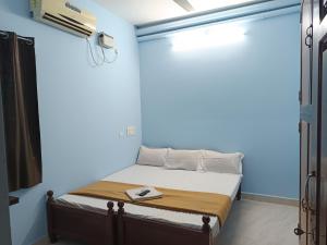 a bedroom with a bed in a blue room at Seasons4 Homestay in Virāmpattinam