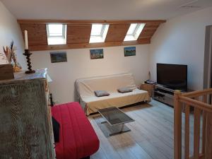 een woonkamer met een bed en een flatscreen-tv bij villa des cascades du hérisson in Bonlieu