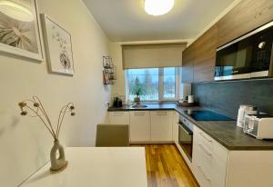 a kitchen with white cabinets and a vase on a table at Otepää Boho Home in Otepää
