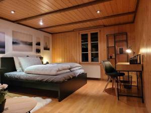 莱西根Mountain View Apartment in Leissigen by Interlaken的一间卧室，配有一张床、一张桌子和一把椅子