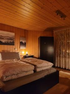 莱西根Mountain View Apartment in Leissigen by Interlaken的带床和木质天花板的卧室