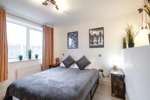 a bedroom with a bed and a large window at Commercial Road Apartments Central Location Wyvern Theatre in Swindon