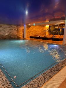 a large swimming pool in a hotel at night at Fabulous Views Silver Mountain 3 Rooms Apartment in Poiana Brasov