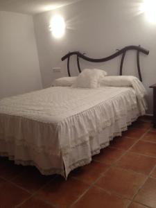 a bedroom with a bed with a white comforter at Casa Rural Minerva in Ronda