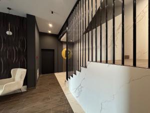 eine Treppe in einem Zimmer mit einem weißen Stuhl in der Unterkunft NEO Doi - central - City of Mara in Timişoara + 36 Fotos