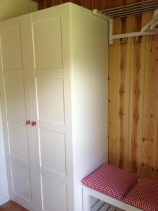 a bedroom with white cabinets and a red bench at Ferienhaus Bruno - Südhanglage mit 2 Schlafzimmern in Feldberg