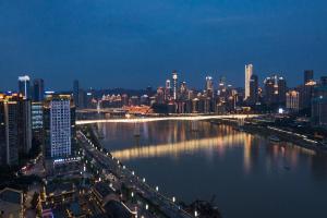 a view of a city at night with a river at ChongQing BackHome Riverview Hotel in Chongqing