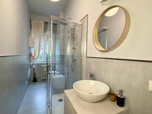 a bathroom with a sink and a shower with a mirror at Casa di Romeo - Valpolicella in Negrar