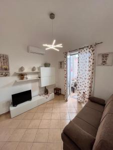 a living room with a couch and a tv at House del Corso Calatafimi in Palermo
