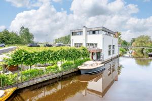 a house on a river with a boat in it at Luxe Wellness Suite Zaandam - Amsterdam in Zaandam