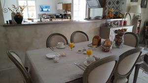 a dining room table with a white table cloth and chairs at Suite dans villa provençale avec parking et piscine in Laneuvelotte