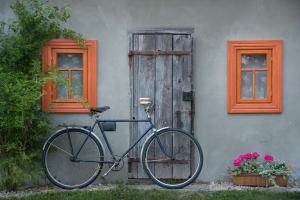 a bike parked in front of a house with a door at beautiful cosy Country Cottage Heaven only for You in Nowy Berezów