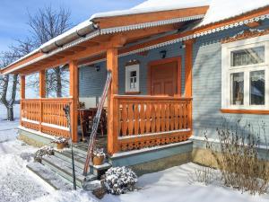 a house with a porch in the snow at beautiful cosy Country Cottage Heaven only for You in Nowy Berezów