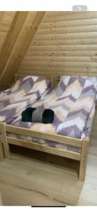a bed in a wooden room with at Villa Roni in Peje