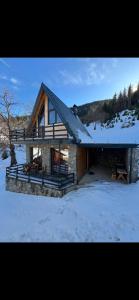 a log cabin with snow on the ground at Villa Roni in Peje