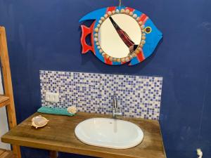 une salle de bain avec un lavabo et un miroir au mur dans l'établissement I Chalés O Sertanejo BG, à Barra Grande