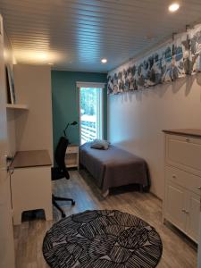a bedroom with a bed and a desk and a window at Hostelli Jokiranta in Lieksa