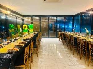 a dining room with long tables and chairs at Ndalo Lodge Oshoek in Oshoek +36 photos