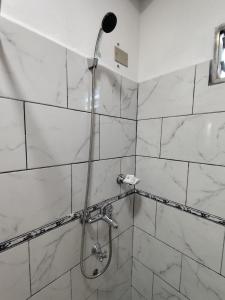 a shower with a shower head in a bathroom at Claudia Apart in Wanda +10 photos