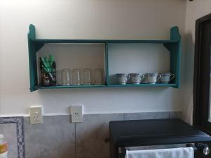 a kitchen with green shelves with bowls on it at Claudia Apart in Wanda