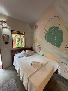 a bedroom with a bed and a butterfly wall at Pousada Flor do Xandó Caraíva in Caraíva +66 photos