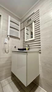 a bathroom with a sink and a mirror at Apartamenty Olimpijskie Szczyrk in Szczyrk
