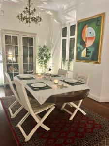 una sala da pranzo con tavolo, sedie e un dipinto di Small stylish room with comfortable queen-size bed in very large, beautifully decorated shared flat in the historic centre of Malaga a Málaga