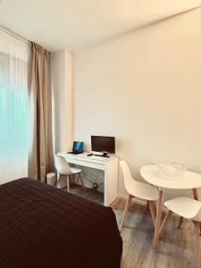 a bedroom with a bed and a desk with a computer at Oriani39 B&B in Bologna