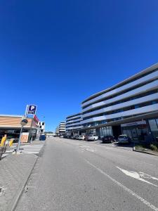 an empty street with cars parked in front of a building at Cozy Luxury Apartment in Aveiro in Aveiro