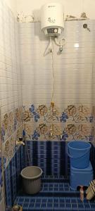 a bathroom with a toilet and a light on the wall at sushma's homestay in Prayagraj