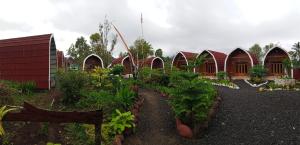 a garden with a row of houses with plants at Indah Damai Cottages in Sidomukti