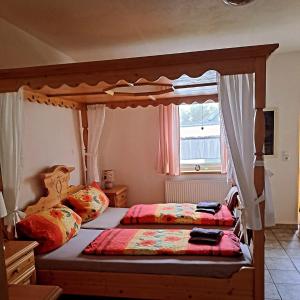 a bedroom with two beds and a canopy bed at Penzion Montana in Zelená Lhota