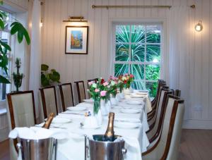 a long table with white table cloth and flowers on it at East Walls Hotel in Chichester