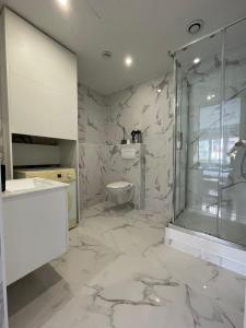 a white bathroom with a shower and a toilet at Studio Côte Bleue in Boulogne-sur-Mer