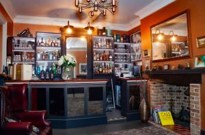 a bar with a fireplace and a mirror at East Walls Hotel in Chichester
