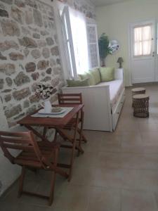 a living room with a couch and a table and chairs at Afroessa Apartment Ithaca in Vathi, Ithaka