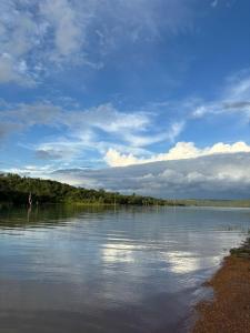 ein großer Wasserkörper mit Bäumen und einem wolkigen Himmel in der Unterkunft Rancho do Guila Pesca & Diversão Corumbá 3 in Abadiânia + 20 Fotos