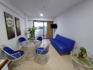 a living room with chairs and a blue couch at Atenea Suite Apartment in Porlamar