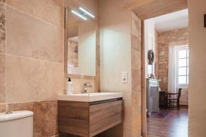 a bathroom with a sink and a toilet and a mirror at logis-des-cordeliers in Saint-Émilion
