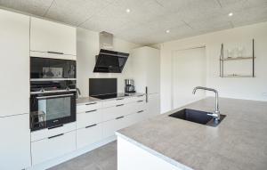 a kitchen with white cabinets and a sink in it at Cozy Home In Glesborg With Wifi in Glesborg
