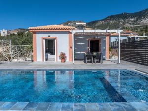 a villa with a swimming pool in front of a house at Fiora Villas in Trapezaki